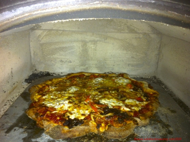 1_masonry-heater-black-oven-cooking-pizza-on-soapstone-slab