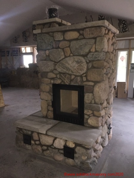 Granite-fieldstone-masonry-heater-with-heated-bench-in-Rhinelander-WI