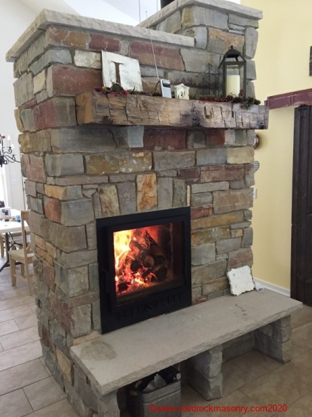 Masonry-heater-with-Chilton-limestone-blend-and-IN-grey-limestone-hearth-and-wood-mantle
