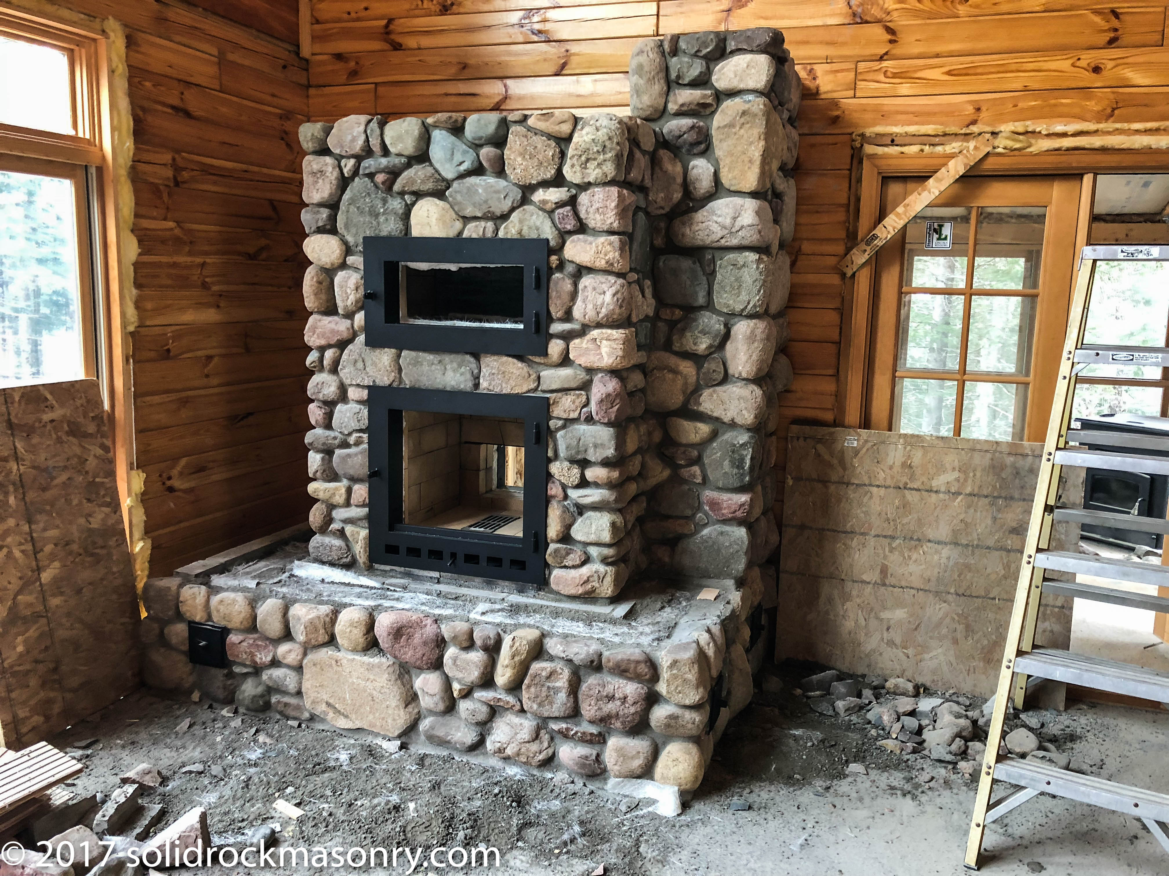 Scantlin SR-22 with white oven, 3 sided heated bench, rear wood loading door and side chimney. Finished with local granite fieldstone.